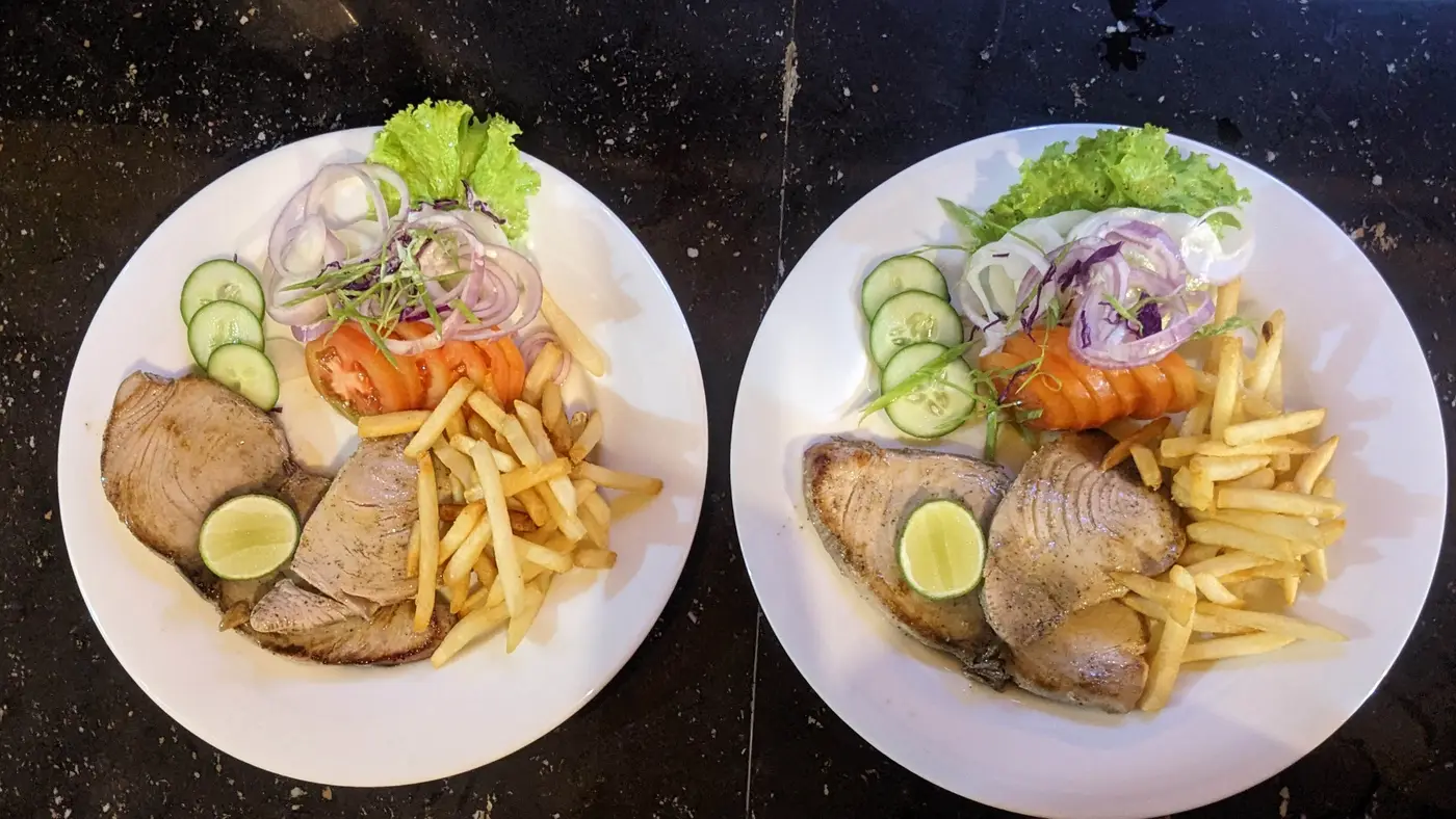 Two plates of grilled tuna steak with salad and fries at the Surfing Life restaurant