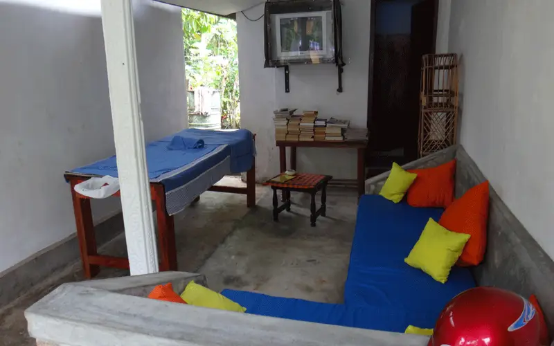 The chill-out area at Surfing Life with blue cushions, colourful pillows and a shelf of books