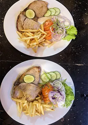 Two plates of grilled tuna with salad and fries served at the Surfing Life restaurant